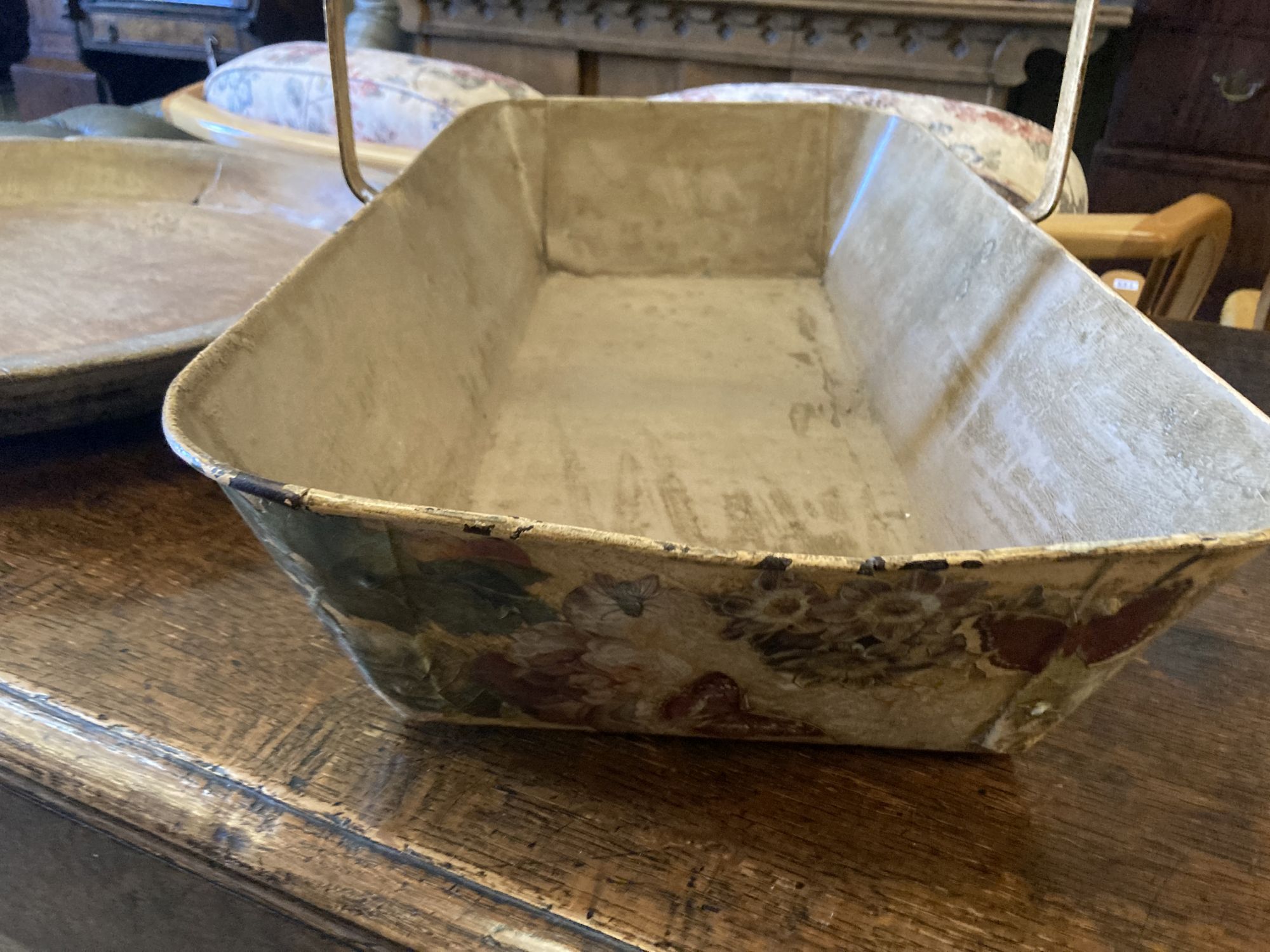 A circular treen shallow bowl and a painted toleware trug, width 69cm, depth 36cm, height 32cm